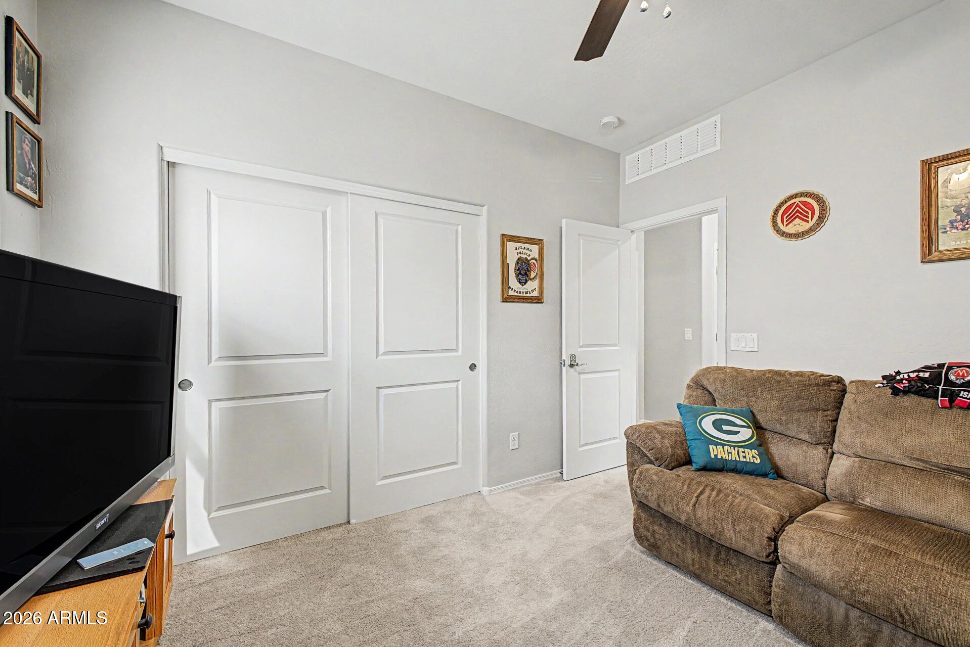 18021 West Indigo Brush Road Goodyear, AZ 85338 - Photo 24 of 47 a living room with furniture and a flat screen tv