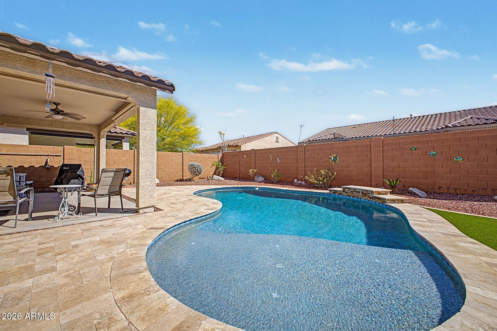 18021 West Indigo Brush Road Goodyear, AZ 85338 - Photo 29 of 47 a view of a swimming pool with lawn chairs