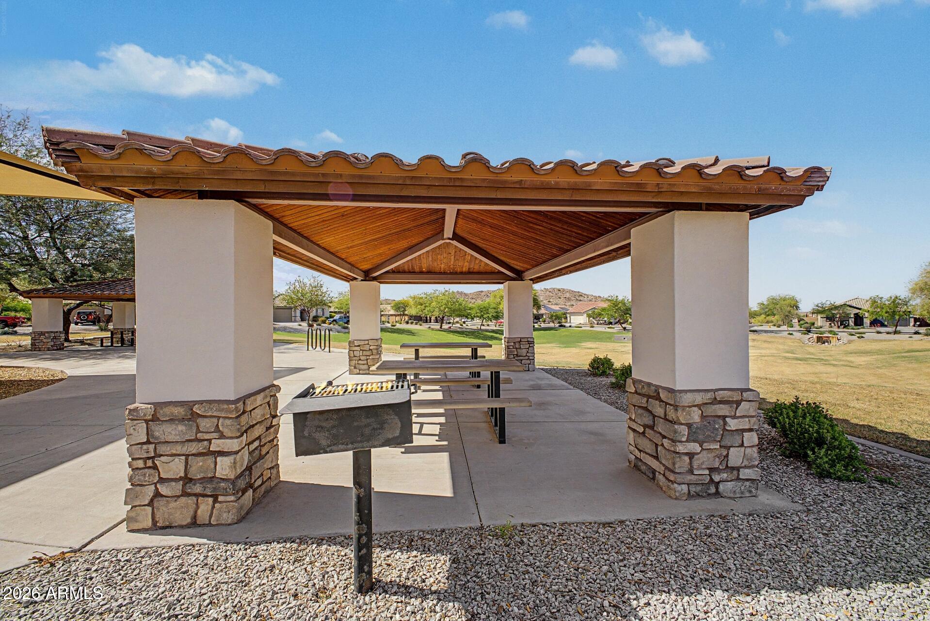 18021 West Indigo Brush Road Goodyear, AZ 85338 - Photo 32 of 47 a view of a patio with chairs and floor to ceiling window