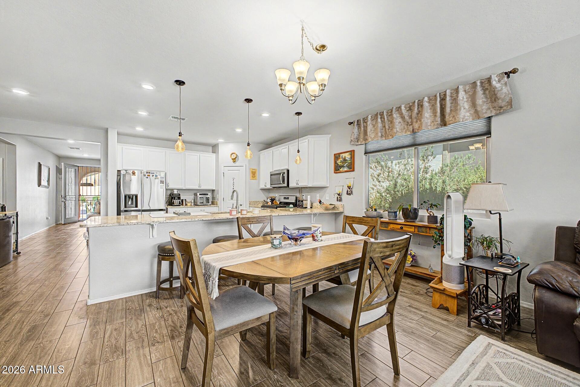 18021 West Indigo Brush Road Goodyear, AZ 85338 - Photo 8 of 47 a view of a dining room with furniture window and wooden floor