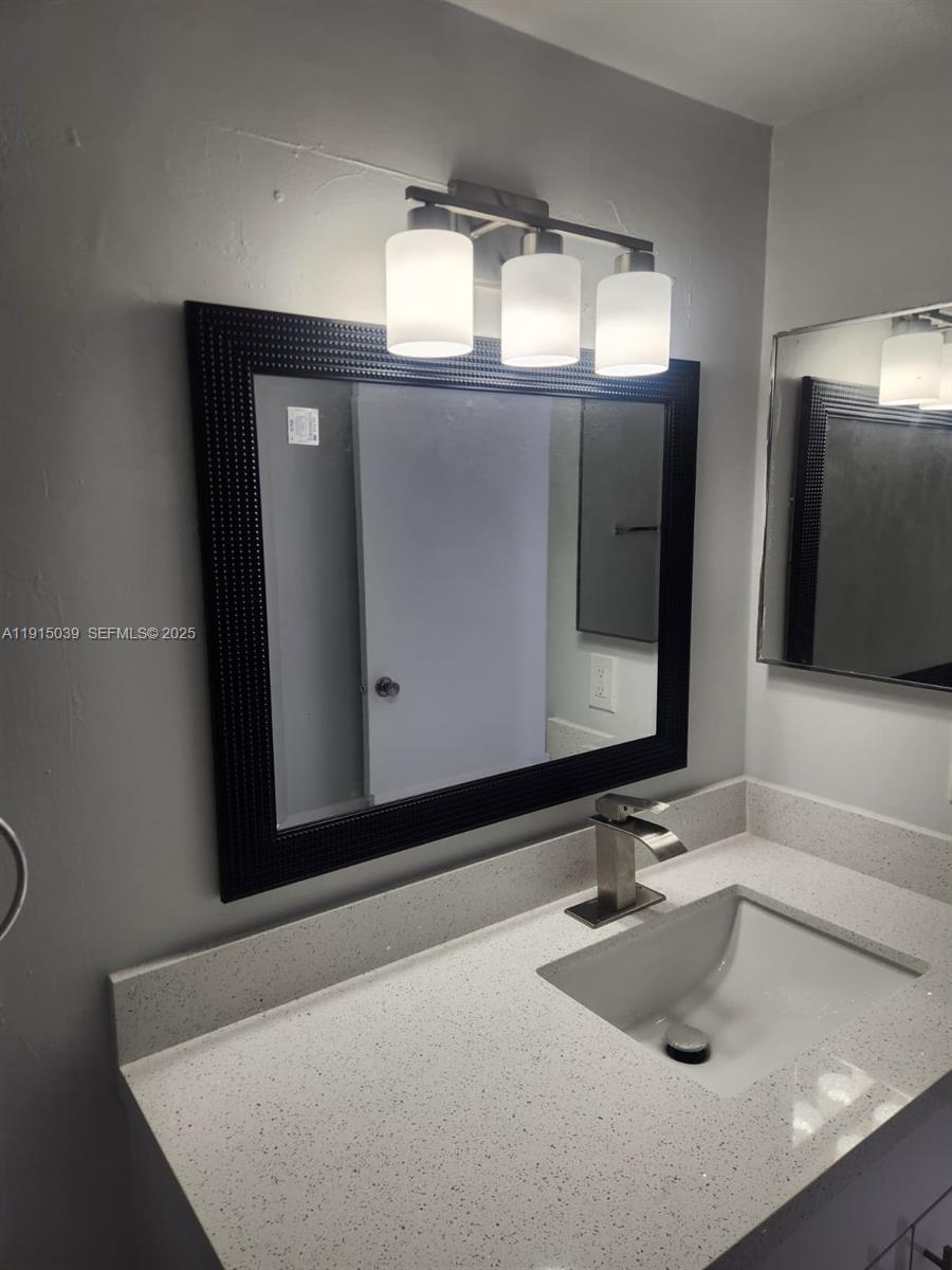 6272 Northwest 186th Street, Unit 201 Hialeah, FL 33015 - Photo 6 of 13 a bathroom with a sink and a mirror