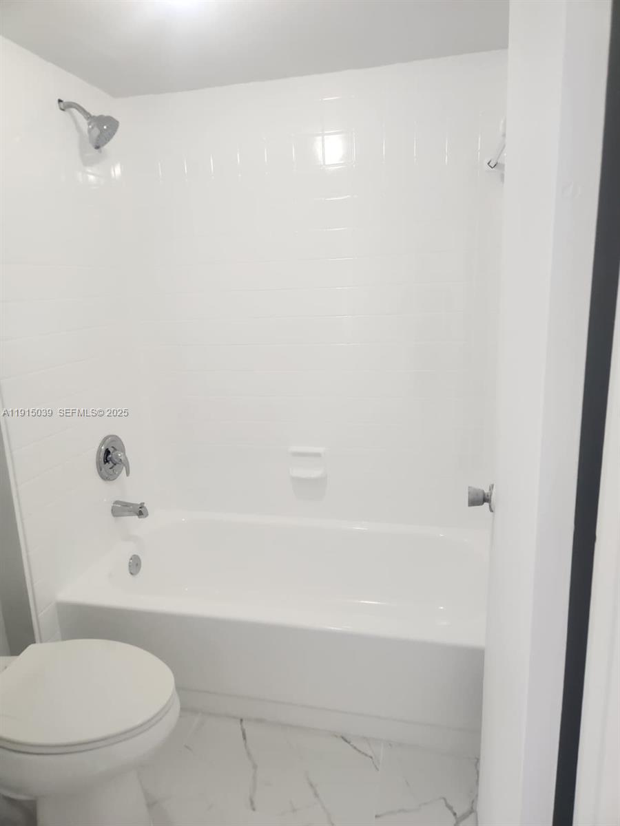 6272 Northwest 186th Street, Unit 201 Hialeah, FL 33015 - Photo 9 of 13 a bathroom with a toilet and a bathtub