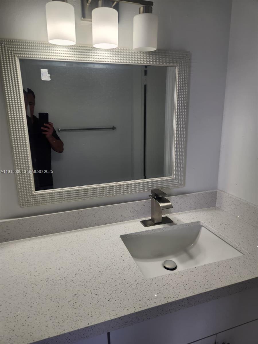 6272 Northwest 186th Street, Unit 201 Hialeah, FL 33015 - Photo 10 of 13 a bathroom with a sink and a mirror