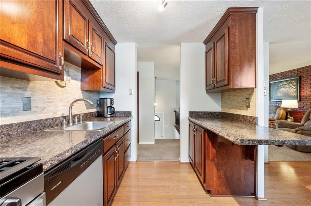 146 Pinehurst Drive Freedom, PA 15042 - Photo 12 of 30 a kitchen with stainless steel appliances granite countertop a sink stove and cabinets