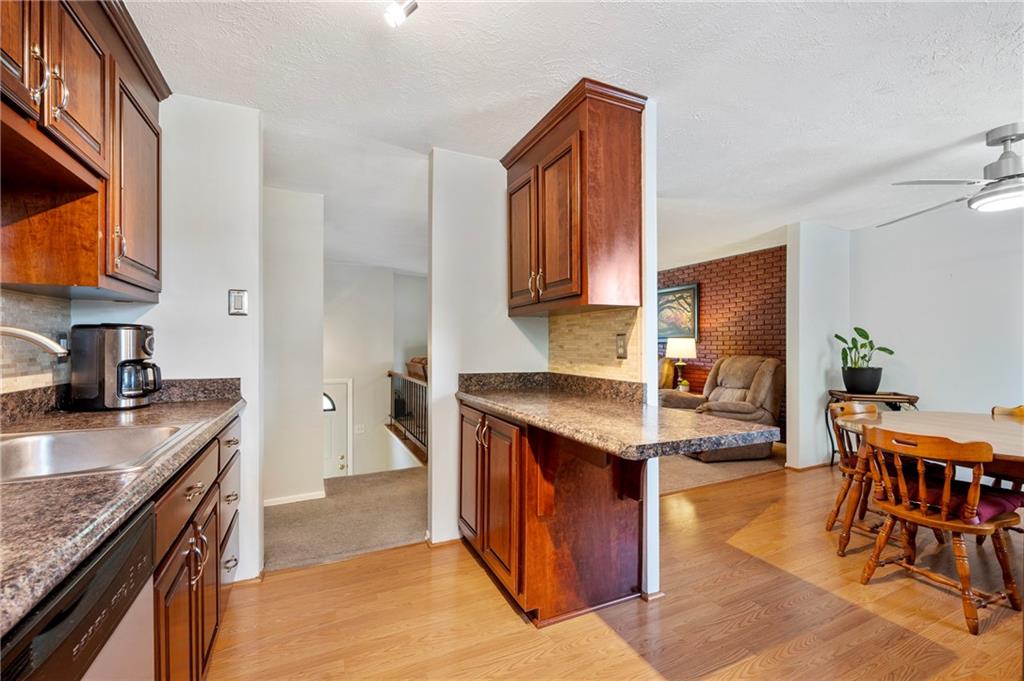 146 Pinehurst Drive Freedom, PA 15042 - Photo 13 of 30 a kitchen with stainless steel appliances granite countertop a stove top oven a sink a dining table and chairs