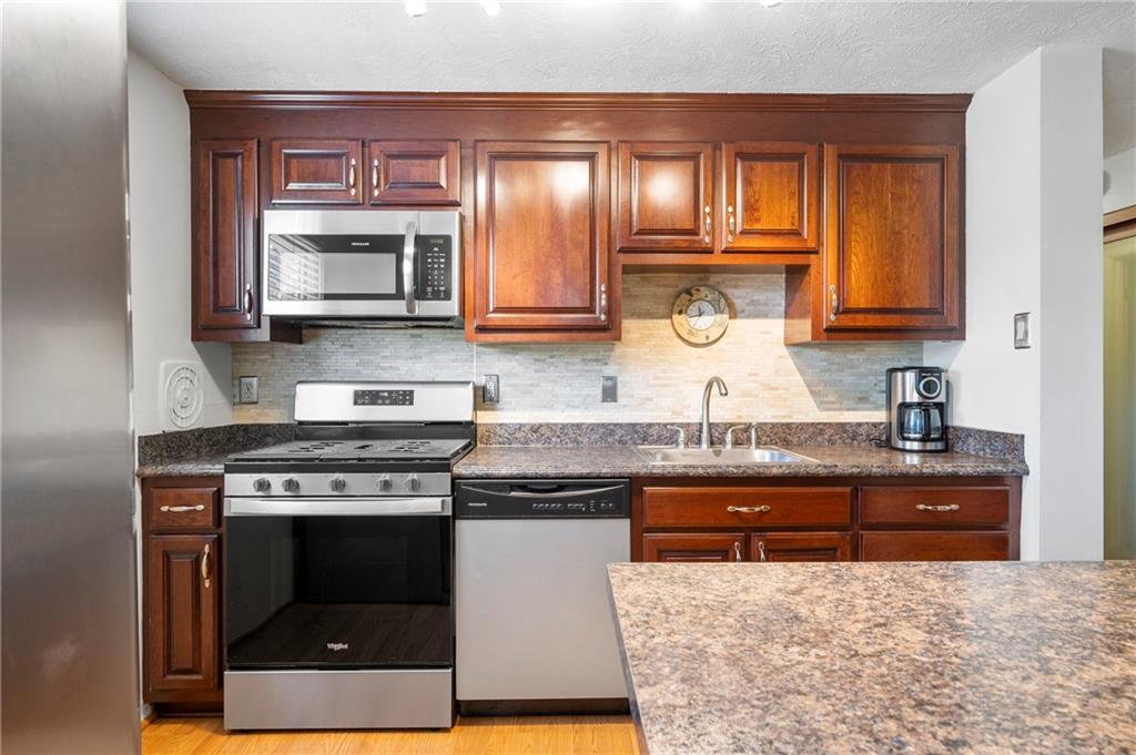 146 Pinehurst Drive Freedom, PA 15042 - Photo 10 of 30 a kitchen with stainless steel appliances granite countertop a stove a sink and a microwave