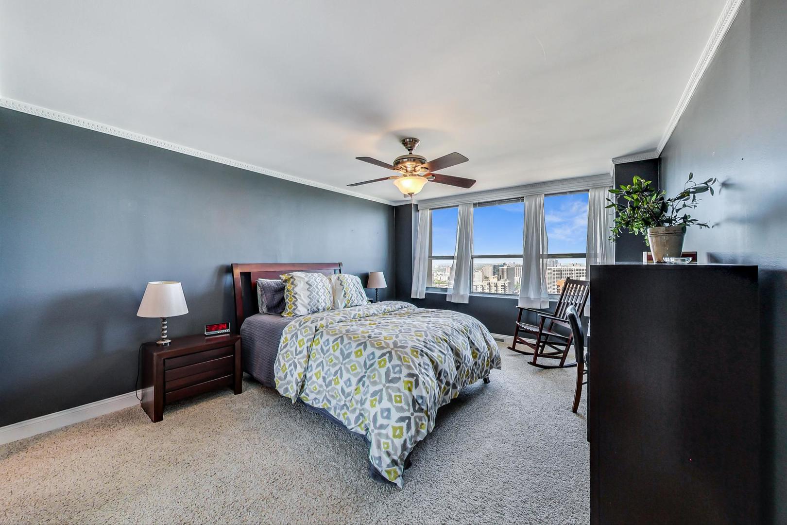 655 West Irving Park Road, Unit 3302 Chicago, IL 60613 - Photo 13 of 37 a bed room with a bed couch and a chandelier