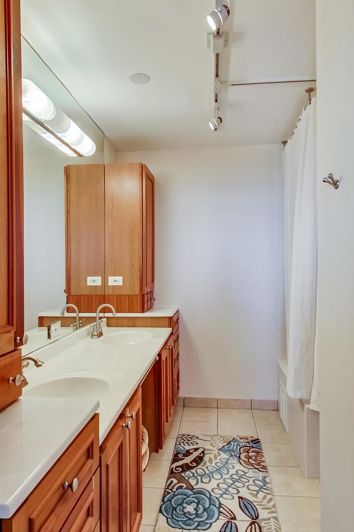 655 West Irving Park Road, Unit 3302 Chicago, IL 60613 - Photo 17 of 37 a bathroom with a sink and a mirror
