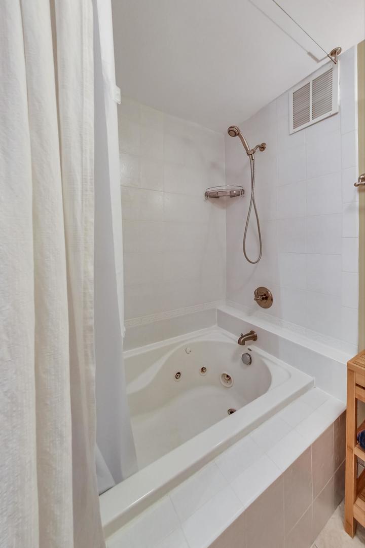 655 West Irving Park Road, Unit 3302 Chicago, IL 60613 - Photo 19 of 37 a white bath tub and shower