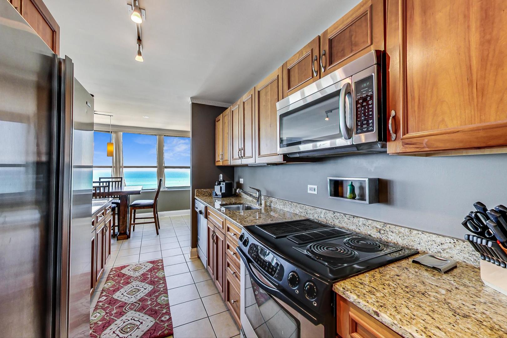 655 West Irving Park Road, Unit 3302 Chicago, IL 60613 - Photo 10 of 37 a kitchen with stainless steel appliances granite countertop a stove a sink and a microwave