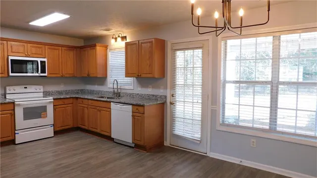 a kitchen with granite countertop wooden cabinets and a stove top oven