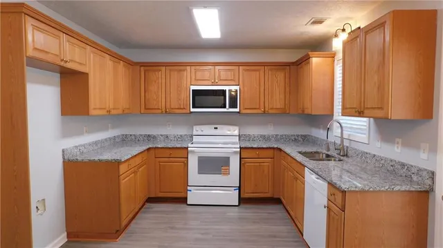 a kitchen with granite countertop cabinets stainless steel appliances and a sink