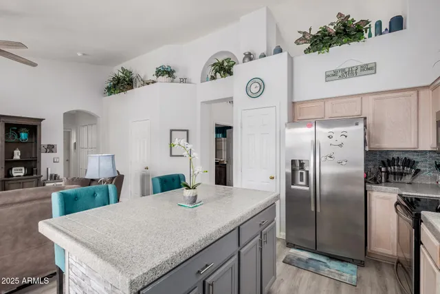 a kitchen with stainless steel appliances granite countertop a refrigerator a sink and a stove