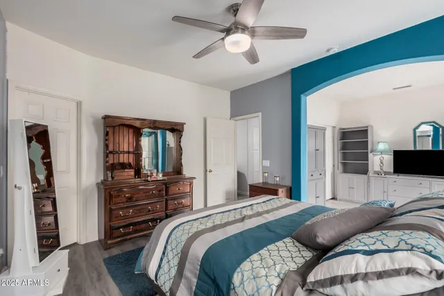 a bedroom with a bed dresser and a flat tv screen