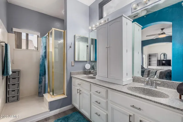 a bathroom with double vanity sinks and a shower