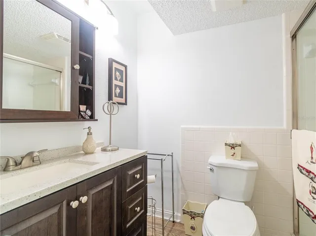 a bathroom with a granite countertop toilet sink and mirror