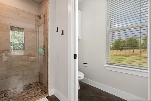 a bathroom with a window and a shower