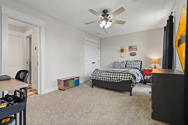 a bedroom with a bed and a flat tv screen on dresser
