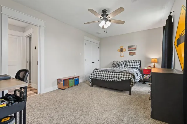 a bedroom with a bed and a flat tv screen on dresser