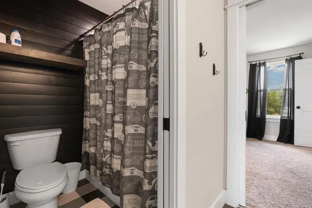a bathroom with a toilet and a shower