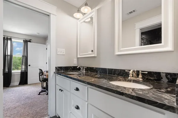 a bathroom with a granite countertop sink and a mirror