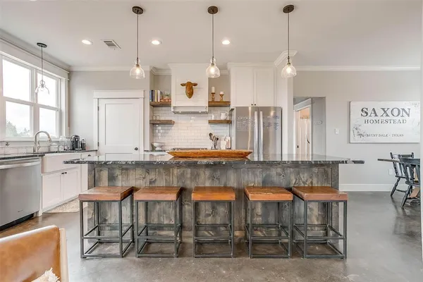 a kitchen with kitchen island granite countertop a table and chairs in it