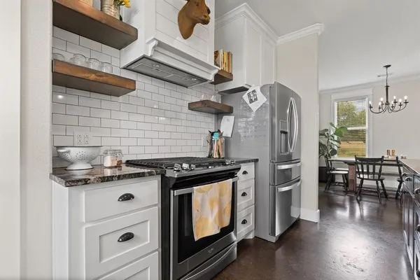 a kitchen with stainless steel appliances granite countertop a stove and a wooden cabinets