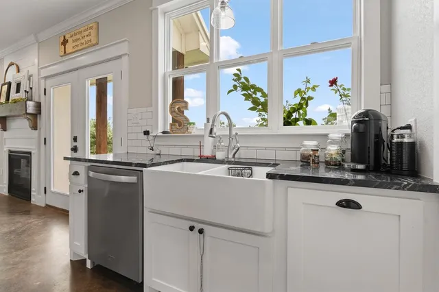 a kitchen with stainless steel appliances granite countertop a sink and a refrigerator