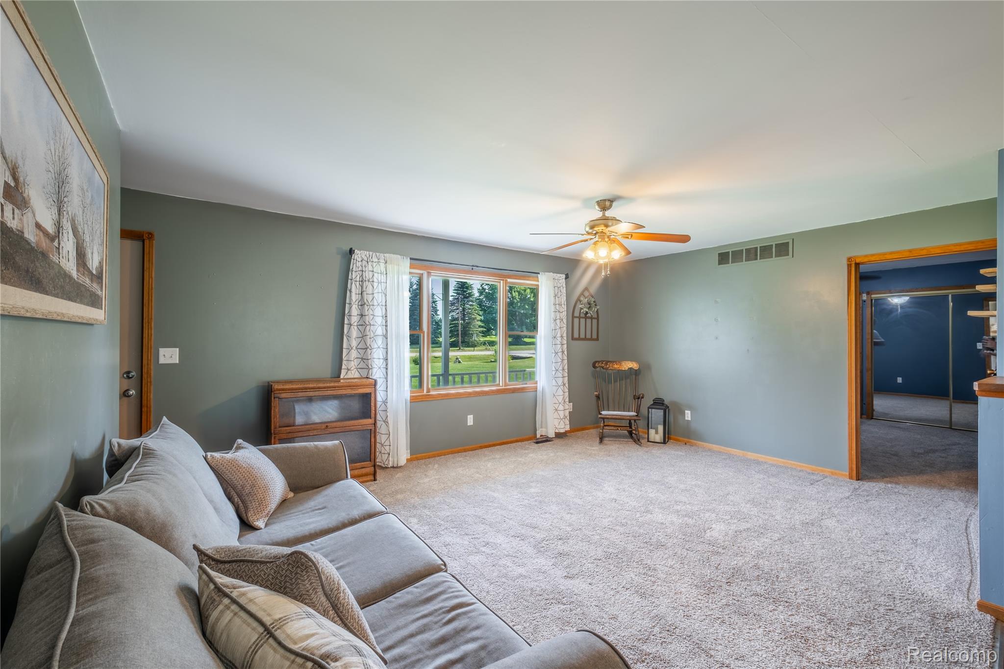 9600 Hamill Road Otisville, MI 48463 - Photo 6 of 32 Spacious living area featuring neutral carpet flooring and a ceiling fan with light fixture