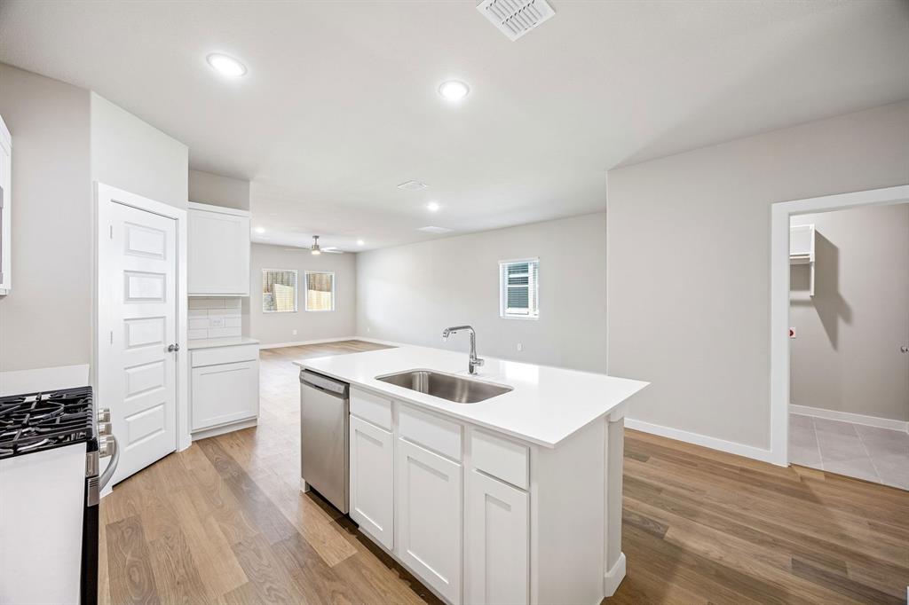 8360 Kingfisher Road Pilot Point, TX 76258 - Photo 11 of 37 a kitchen that has a sink a stove and wooden floor