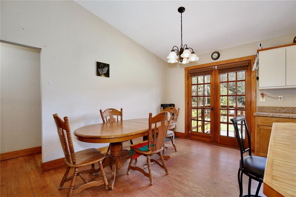 425 Mercers Fernery Road DeLand, FL 32720 - Photo 11 of 54 a dining room with furniture a chandelier and wooden floor