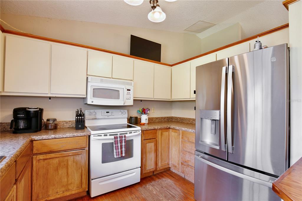 425 Mercers Fernery Road DeLand, FL 32720 - Photo 14 of 54 a kitchen with stainless steel appliances white cabinets and a refrigerator