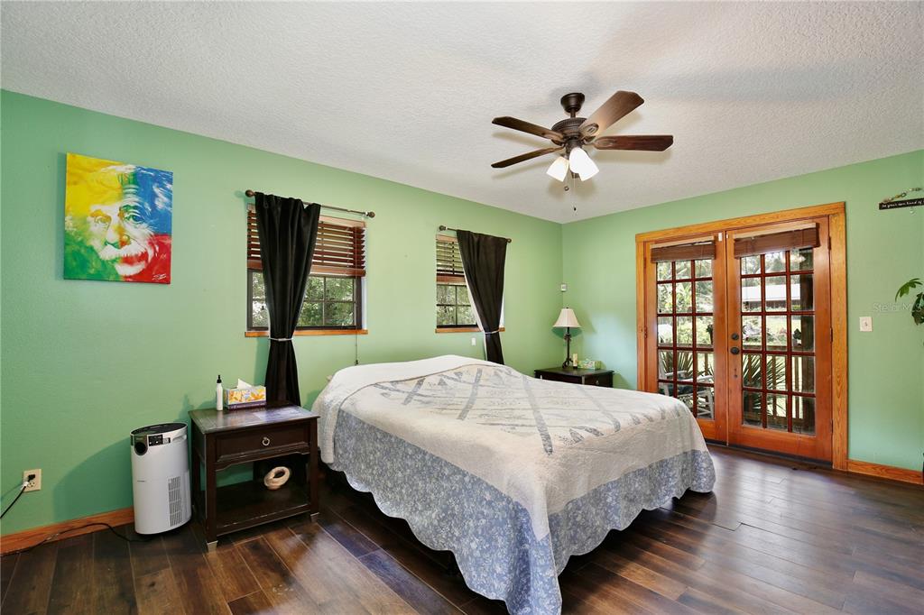 425 Mercers Fernery Road DeLand, FL 32720 - Photo 16 of 54 a bedroom with a bed and wooden floor
