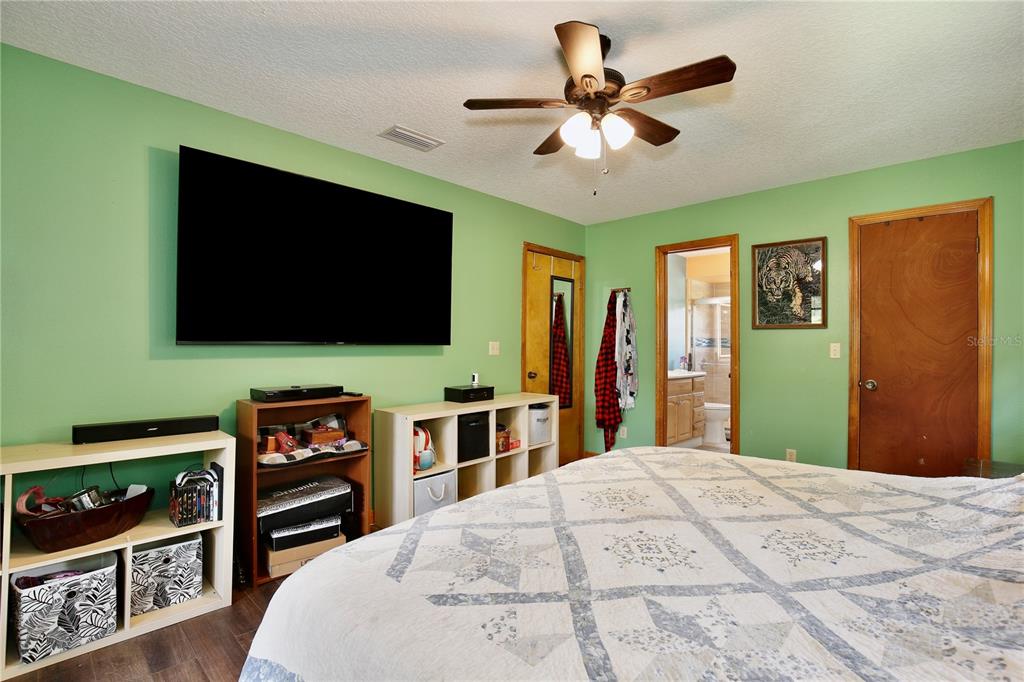 425 Mercers Fernery Road DeLand, FL 32720 - Photo 17 of 54 a bedroom with a bed and a flat screen tv