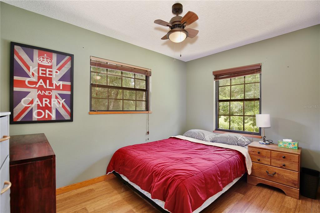 425 Mercers Fernery Road DeLand, FL 32720 - Photo 20 of 54 a bedroom with a bed and wooden floor