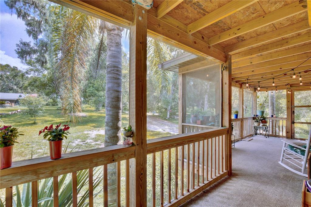 425 Mercers Fernery Road DeLand, FL 32720 - Photo 2 of 54 a view of a porch with wooden floor and furniture