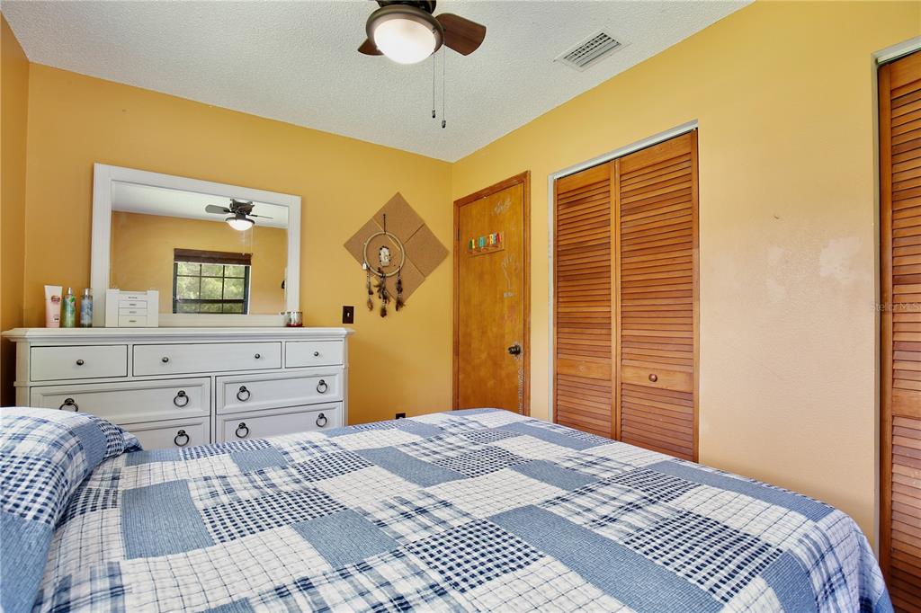 425 Mercers Fernery Road DeLand, FL 32720 - Photo 24 of 54 a bedroom with a bed and a dresser