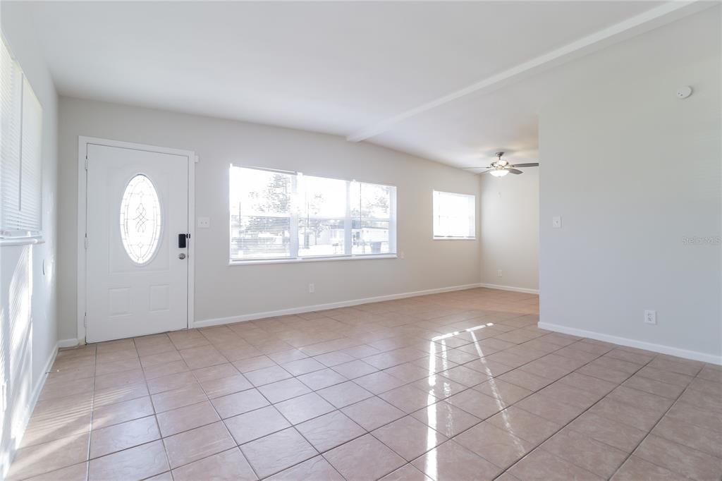 11623 Cameron Street Orlando, FL 32817 - Photo 2 of 16 an empty room with windows and mirror