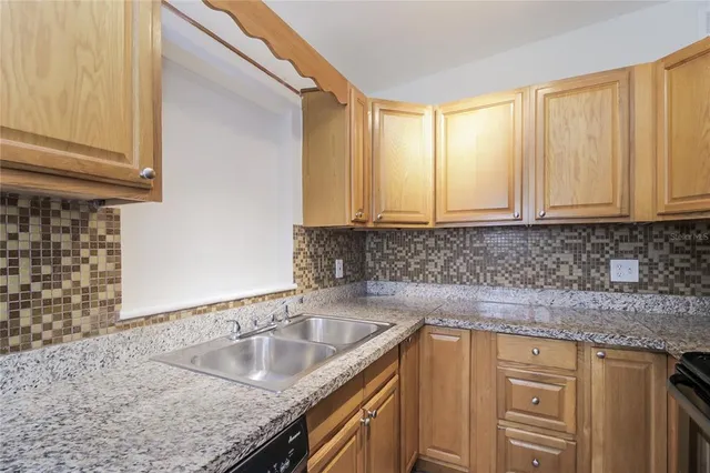 a kitchen with granite countertop a sink and cabinets