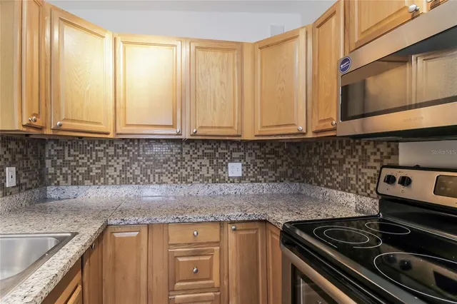 a kitchen with granite countertop a sink stove and cabinets