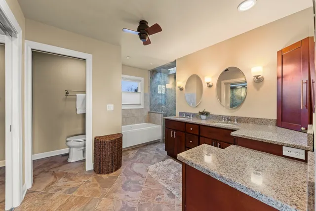 a spacious bathroom with a granite countertop sink and a mirror