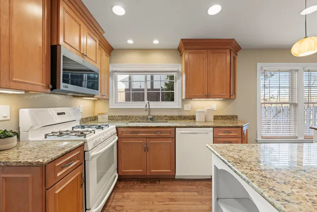 a kitchen with stainless steel appliances granite countertop wooden cabinets stove top oven and sink