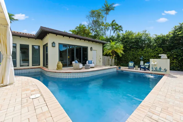 a view of a patio with table and chairs potted plants and palm tree