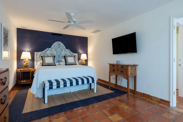 a bedroom with a bed and large windows