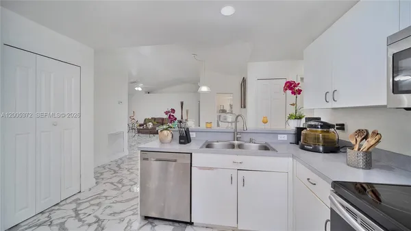 a kitchen with sink refrigerator and microwave
