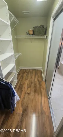 a view of walk in closet with empty racks