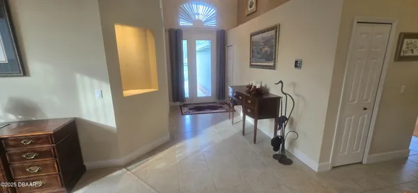 a view of a hallway with workspace and a window