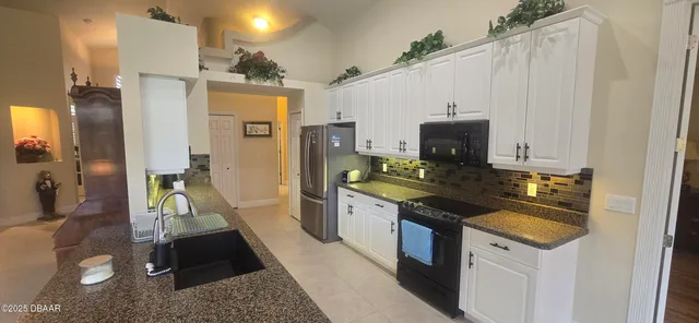 a large kitchen with stainless steel appliances granite countertop a sink dishwasher stove and refrigerator