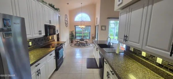 a kitchen with sink stove refrigerator and cabinets