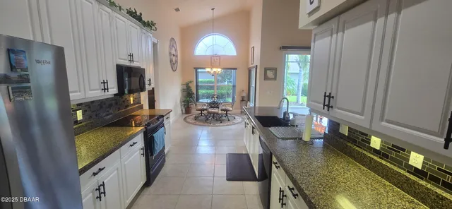 a kitchen with sink stove refrigerator and cabinets